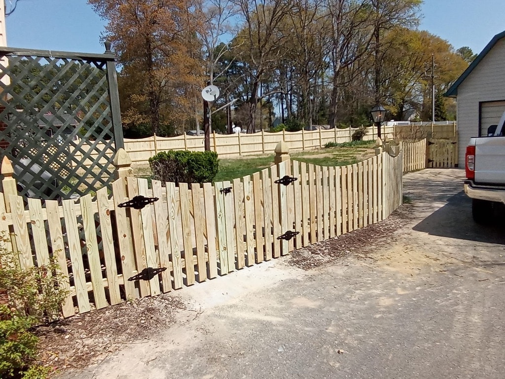 Curved wood picket fence with gate installed around a yard in Bon Air.